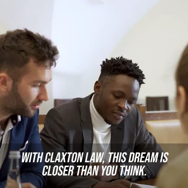 Still from the Claxton Law Group naturalization video ad, an attorney going through paperwork with a client across a desk